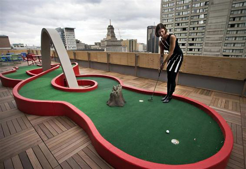Гуглов запосленик показује како се користи мини-терен  за голф на балкону нове Гуглове канцеларије у Торонту...