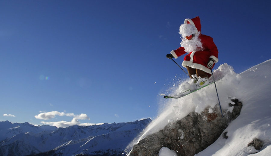 У костиму Дједа Мраза, учитељ скијања Алберто Рончи изводи скијашке скокове у мјесту Мадона ди Кампиљо у сјеверној Италији...